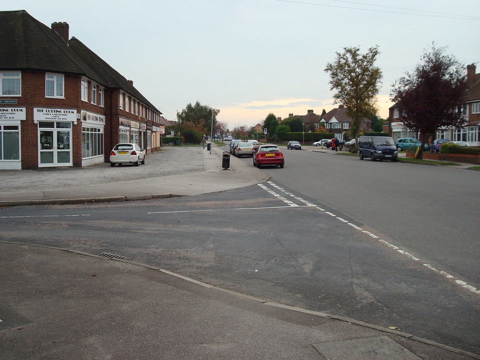 A 1930s suburban street corner with semi-detached houses and a parade of shops in Castle Bromwich, Birmingham